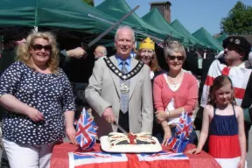 Nick Hollinghurst cuts Cake at Tring Farmers Market Jubilee Event