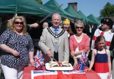 Nick Hollinghurst cuts Cake at Tring Farmers Market Jubilee Event